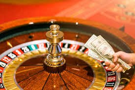 Seorang pria menikmati hiburan sports dan casino melalui smartphone di ruang santai kota Jakarta
